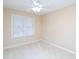 Neutral-toned bedroom features a ceiling fan and a large window for natural light at 703 E Stanley St, Four Oaks, NC 27524