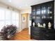 Dining area featuring a black buffet with glass door storage, hardwood flooring, and a sunlit window at 703 E Stanley St, Four Oaks, NC 27524
