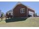 Brick home's backyard featuring well-kept landscaping and partial fencing at 703 E Stanley St, Four Oaks, NC 27524