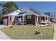 Inviting brick home featuring a two-car garage, well-kept lawn, and charming front porch area at 703 E Stanley St, Four Oaks, NC 27524