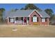 Charming red brick home featuring a cozy front porch with white railing and rocking chairs at 703 E Stanley St, Four Oaks, NC 27524