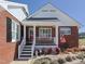 Cozy front porch with a bench and decor, providing a warm welcome to this charming brick home at 703 E Stanley St, Four Oaks, NC 27524