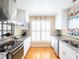 Bright kitchen with stainless appliances, granite counters, white cabinets, and hardwood floors at 703 E Stanley St, Four Oaks, NC 27524