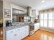 Bright kitchen featuring stainless steel appliances, granite countertops, and light-colored cabinetry with hardwood floors at 703 E Stanley St, Four Oaks, NC 27524