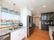 Open kitchen with stainless steel appliances, light-colored cabinetry, and hardwood flooring at 703 E Stanley St, Four Oaks, NC 27524
