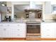 Modern kitchen with stainless steel appliances, granite countertops, and white cabinets overlooking an open layout at 703 E Stanley St, Four Oaks, NC 27524