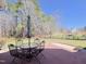 Outdoor patio with table and chairs offering views of the wooded backyard at 703 E Stanley St, Four Oaks, NC 27524