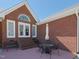 Charming brick patio with steps, table, chairs, and white umbrella, perfect for outdoor relaxation and entertaining at 703 E Stanley St, Four Oaks, NC 27524