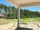 A covered porch with view of a spacious backyard and tree line, perfect for outdoor living and entertaining at 79 Tee Time Ter, Benson, NC 27504