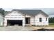Unfinished exterior of a one story home showing construction wrap, window and door openings, and an attached two car garage at 79 Tee Time Ter, Benson, NC 27504