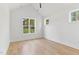 Bright bedroom featuring wood-look flooring, white walls, and large windows offering natural light at 8487 Old Us 421, Lillington, NC 27546