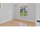 Bright bedroom with wood-look flooring, white walls, and a large window offering ample natural light at 8487 Old Us 421, Lillington, NC 27546