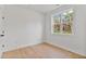 Bright bedroom with wood-look flooring, white walls, and a large window offering natural light at 8487 Old Us 421, Lillington, NC 27546