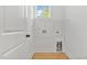 Bright laundry room with white walls, wood-look floors, wire shelving, and washer/dryer hookups at 8487 Old Us 421, Lillington, NC 27546