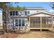 Rear view of home showcases a screened in porch and well-manicured lawn at 934 Woodland Rd, Creedmoor, NC 27522