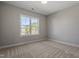 A bright bedroom has carpet, a large window, and neutral wall color at 934 Woodland Rd, Creedmoor, NC 27522