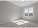 A sunlit bedroom has carpet, neutral walls, and large window with a wood frame at 934 Woodland Rd, Creedmoor, NC 27522