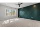 An inviting bedroom features a dark green accent wall, large window, and a ceiling fan at 934 Woodland Rd, Creedmoor, NC 27522