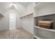 A bright walk-in closet features carpeted floors, shelves, and rod for hanging clothes at 934 Woodland Rd, Creedmoor, NC 27522