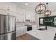 Modern kitchen featuring stainless steel appliances, a large island, and elegant lighting fixtures at 934 Woodland Rd, Creedmoor, NC 27522