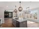 Open concept kitchen featuring an island with a sink and seating, stainless steel appliances, and hardwood floors at 934 Woodland Rd, Creedmoor, NC 27522