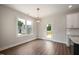 Well-lit dining area with a modern chandelier and views of the backyard through a large window at 9600 Stallings Rd, Spring Hope, NC 27882