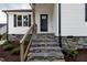 Close-up of the front entrance with stone steps and wood railing, showcasing quality craftsmanship at 9600 Stallings Rd, Spring Hope, NC 27882