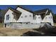 A close exterior shot of a newly constructed home with framed windows, a moisture barrier, and cinder block foundation at 9600 Stallings Rd, Spring Hope, NC 27882