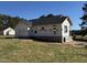 This exterior shows a newly constructed home with a dark roof, framed windows, and newly installed moisture barrier at 9600 Stallings Rd, Spring Hope, NC 27882