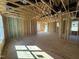 Framed interior featuring open stud walls, subfloor, ductwork, and natural light at 9600 Stallings Rd, Spring Hope, NC 27882