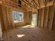 Framed interior view of subfloor, stud walls and door with natural light from the window and door at 9600 Stallings Rd, Spring Hope, NC 27882