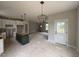 Spacious kitchen with modern lighting, white cabinetry, and dark green kitchen island at 9600 Stallings Rd, Spring Hope, NC 27882