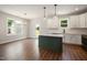 Bright, open kitchen with a center island, white cabinetry, and modern pendant lights at 9600 Stallings Rd, Spring Hope, NC 27882