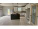 Bright kitchen featuring white cabinets, a stylish pantry door, and a dark green kitchen island at 9600 Stallings Rd, Spring Hope, NC 27882