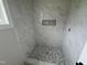 Elegant shower with marble-look tile walls, mosaic floor, and corner niche at 9600 Stallings Rd, Spring Hope, NC 27882