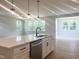 Bright kitchen with white countertops, an island with a black faucet, stainless steel dishwasher, and wood floors at 98 Tee Time Ter, Benson, NC 27504