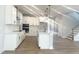 Modern kitchen boasts sleek white cabinets, a large island, and stainless steel appliances, perfect for cooking at 98 Tee Time Ter, Benson, NC 27504
