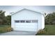 New single car garage with white siding, concrete driveway and attractive surrounding landscape at 101 Parkland Dr, Pittsboro, NC 27312