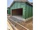 The open garage features a concrete floor, framed by wood studs and modern exterior paneling at 101 Parkland Dr, Pittsboro, NC 27312