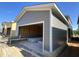 New garage construction featuring gray siding, overhead door opening, and materials stored inside at 101 Parkland Dr, Pittsboro, NC 27312