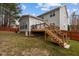 This backyard deck is accessible from the second story with wooden stairs and a black metal railing at 1046 Upchurch Farm Ln, Cary, NC 27519