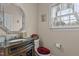 Bathroom featuring granite vanity top, decorative mirror, and window with natural light at 1046 Upchurch Farm Ln, Cary, NC 27519