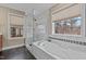 Bathroom features a soaking tub with a tiled surround, a glass-enclosed shower, and multiple windows at 1046 Upchurch Farm Ln, Cary, NC 27519
