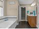 Bathroom showcases a soaking tub, vanity with modern fixtures, and a doorway to a walk-in closet at 1046 Upchurch Farm Ln, Cary, NC 27519