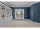 Bedroom featuring built-in bookshelves, natural light from the window, and neutral-colored carpet at 1046 Upchurch Farm Ln, Cary, NC 27519