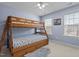 bedroom with a wooden bunk bed and two windows, creating a playful and bright space at 1046 Upchurch Farm Ln, Cary, NC 27519