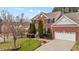 Well-maintained two-story brick house with a green lawn, driveway, and two-car garage at 1046 Upchurch Farm Ln, Cary, NC 27519