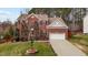 Front view of a brick house featuring a well-kept lawn, landscaping, and attached two-car garage at 1046 Upchurch Farm Ln, Cary, NC 27519