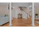 Hallway with hardwood floors, columns, and a staircase leading to the upper level at 1046 Upchurch Farm Ln, Cary, NC 27519