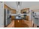 Kitchen boasts stainless steel appliances, wood cabinets, and island with counter seating at 1046 Upchurch Farm Ln, Cary, NC 27519